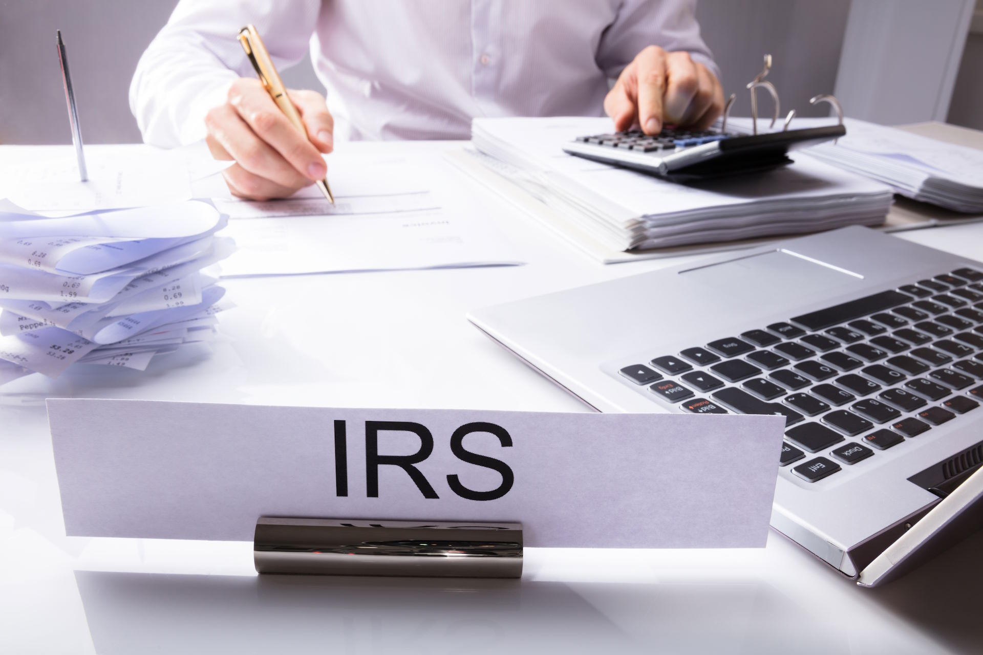 Irs,Nameplate,In,Front,Of,Accountant,Calculating,Tax,On,Desk